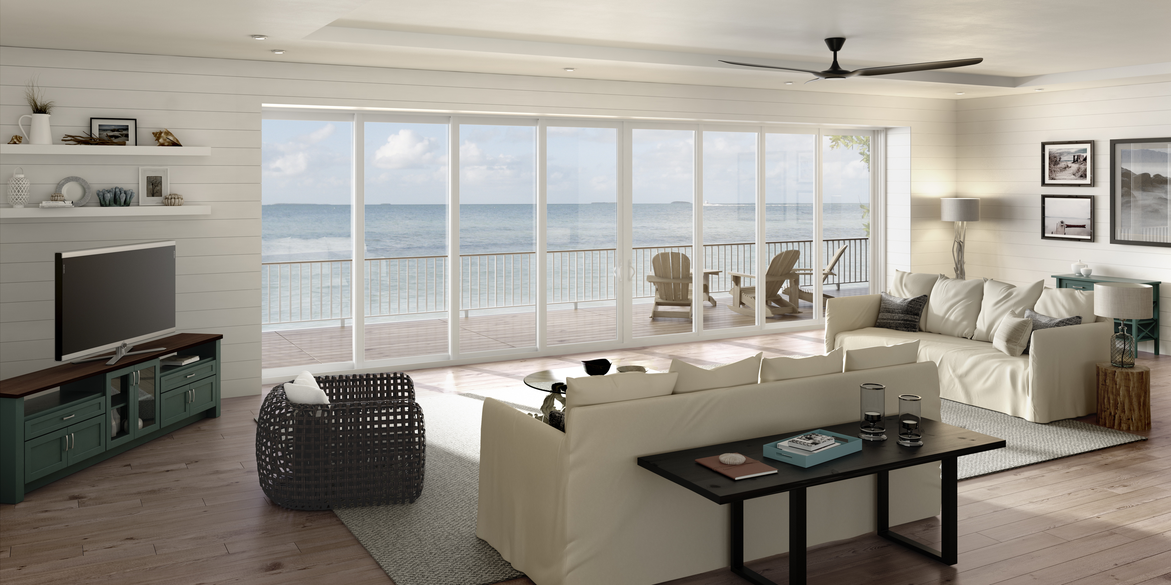 Puertas corredizas de vidrio de varios paneles PGT SGD5570 que abarcan el salón de una casa en la playa con vistas al mar